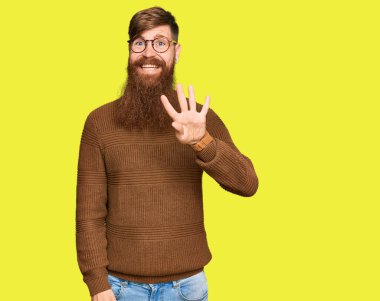 Genç İrlandalı kızıl elbiseli ve gözlüklü adam dört numarayı gösterip işaret ederken kendinden emin ve mutlu gülümsüyor.. 