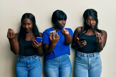 Üç Afro-Amerikalı genç arkadaş akıllı telefon kullanıyor. Paralı jest yapıyorlar. Maaş istiyorlar. 