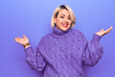 Güzel sarışın ve cüsseli bir kadın mor arka plan üzerine balıkçı yaka kazak giyiyor ve elleri ve kolları havada kafası karışmış bir ifade takınıyor. Şüphe kavramı.