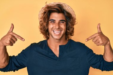 Yaz şapkası takan, kendine güvenen, gülümseyen, kendini gururlu ve mutlu gösteren genç bir İspanyol.. 