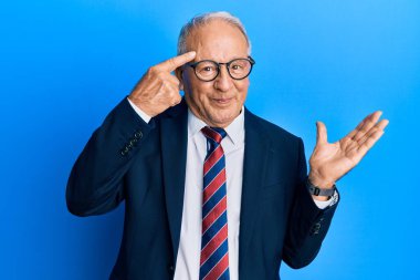 İş elbisesi giymiş, kravat takmış, kafası karışmış ve avuç içi açık bir şekilde fotokopi alanını göstermekten rahatsız olmuş beyaz bir adam. Bunu bir düşün.. 