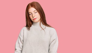 Yüzünde ciddi bir ifade olan sıradan bir kazak giyen okumuş genç bir kadın. Basit ve doğal bir şekilde kameraya bakıyorsun.. 