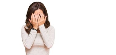 Genç esmer kadın, günlük kıyafetler ve ağlarken yüzünü ellerle kapatan üzgün yüzlü gözlük takıyor. depresyon kavramı. 