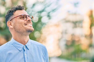 Genç İspanyol işadamı gülümseyerek şehirde mutlu mesut duruyor..