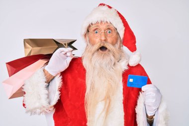 Noel Baba kostümü giymiş yaşlı bir adam elinde alışveriş çantaları ve kredi kartı tutuyordu. Şaşırmış, şaşırmış ve şaşırmış bir ifade, korku ve heyecanlı bir yüz vardı.. 
