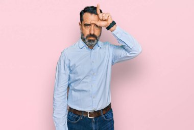 Orta yaşlı sakallı bir adam iş gömleği giyiyor. Alnında parmakları olan insanlarla dalga geçiyor. Ezik hareketler yapıyor, alay ediyor ve hakaret ediyor.. 