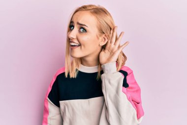 Güzel, beyaz bir kadın spor ceket giyiyor, sırıtıyor, kulağına fısıldıyor ve söylenti ya da dedikoduları dinliyor. Sağırlık kavramı. 