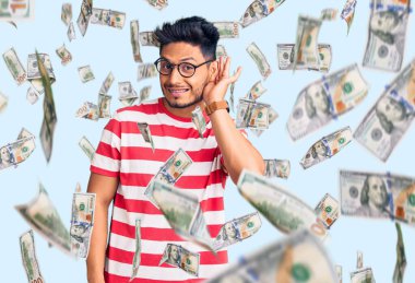 Yakışıklı Latin Amerikalı, sıradan kıyafetler ve gözlük takan, ağzı kulaklarında gülümseyen dedikoduları ve dedikoduları dinleyen genç adam. Sağırlık kavramı.