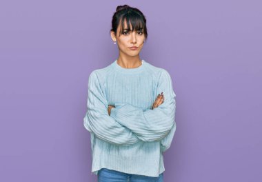 Gündelik kıyafetler giyen genç İspanyol kadın şüpheci ve gergin. Yüzünde çapraz kollu tasvip etmeyen ifade. negatif kişi. 