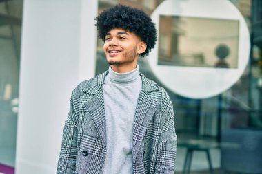 Genç Afrikalı Amerikalı iş adamı şehirde mutlu mesut dikiliyor..