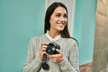 Genç İspanyol kadın şehirde kamerayla gülümsüyor..