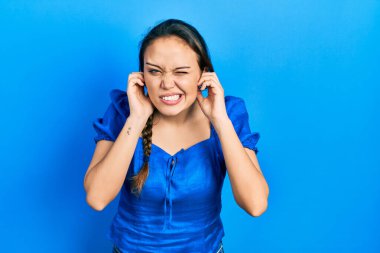 Gürültülü müzik sesi için kulaklarını parmaklarıyla kapatan İspanyol asıllı genç bir kız. sağır kavramı. 