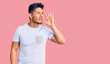 Yakışıklı Latin Amerikalı genç adam gündelik kıyafetler giyip el ele tutuşarak bağırıyor ve bağırıyordu. iletişim konsepti. 