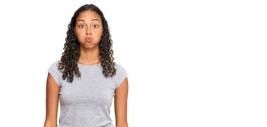 Sıradan kıyafetler giyen, komik yüzlü, yanak şişiren Afro-Amerikalı genç bir kız. Havayla şişmiş ağız, çılgın bir ifade.. 