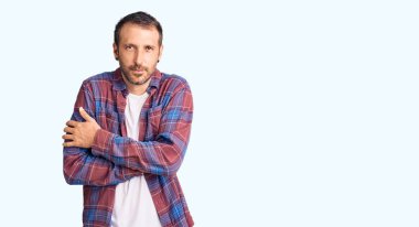 Genç ve yakışıklı bir adam günlük kıyafetler giyiyor. Kış soğuğu için titriyor ve donuyor. Yüzünde üzgün ve şok ifadesi var. 