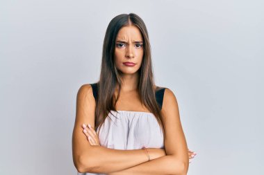 Gündelik kıyafetler giyen genç İspanyol kadın şüpheci ve gergin. Yüzünde çapraz kollu tasvip etmeyen ifade. negatif kişi. 