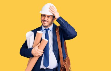 Mimar şapkalı ve deri çantalı genç İspanyol adam elinde planlar, şaşırmış ve sinirli yüzüyle baskı altında ve hayal kırıklığına uğramış. 