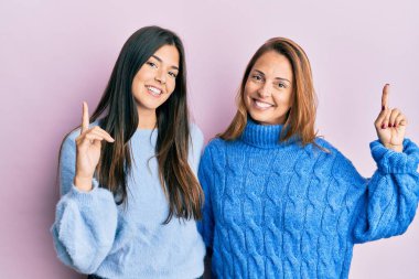 Kışlık yün kazak giyen anne ve kızın İspanyol ailesi başarılı bir fikirle işaret ediyor. Heyecanlı ve mutlu. Bir numara.. 