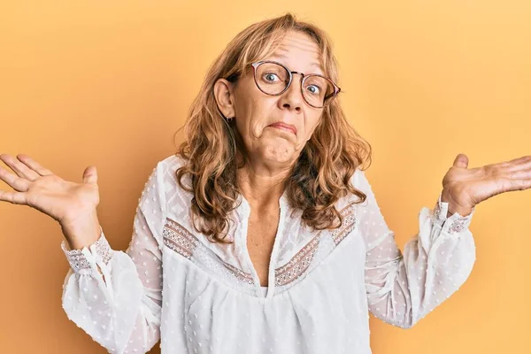 Middelbare Leeftijd Blonde Vrouw Dragen Casual Kleding Gele Achtergrond Clueless — Stockfoto