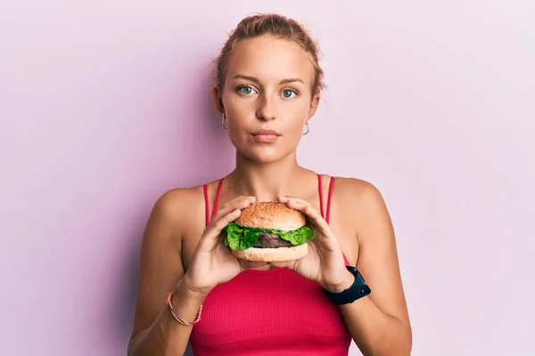 Krásná Běloška Chutný Klasický Burger Uvolněný Vážným Výrazem Tváři Jednoduchý — Stock fotografie