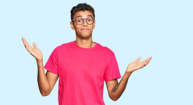 Genç, yakışıklı, Afro-Amerikan bir adam. Sıradan kıyafetler giyiyor. Hiçbir şeyden habersiz ve elleri havada, kafası karışmış bir ifade takınıyor. şüphe kavramı. 