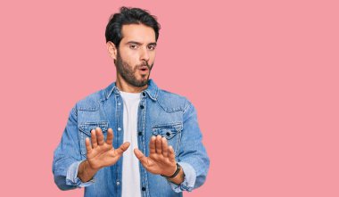 Latin asıllı genç bir adam, sıradan kıyafetler giyip avuçlarını hareket ettiriyor. Korkmuş ve iğrenç bir ifadeyle reddediyor. Dur ve yasakla. 