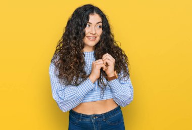 Gündelik kıyafetler giyen genç İspanyol kız. Gergin ve heyecanlı. Elleri çenesinde yan tarafa bakıyor. 