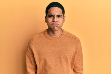 Kış süveteri giyen genç, yakışıklı İspanyol adam komik yüzlü yanakları şişiriyor. Havayla şişmiş ağız, çılgın bir ifade.. 