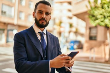 Şehirde akıllı telefon kullanan genç bir iş adamı..