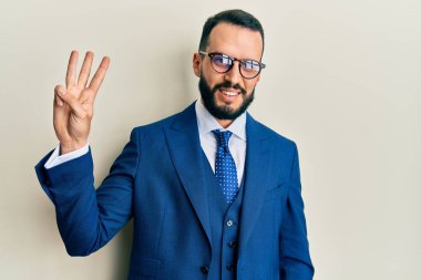 Sakallı, takım elbiseli ve kravatlı genç adam üç numaralı parmaklarıyla kendini beğenmiş ve mutlu gülümserken onu gösteriyor.. 