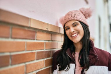 Genç İspanyol kız gülümseyerek şehirde mutlu mesut dikiliyor..