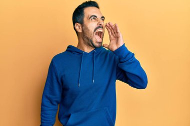 Latin asıllı genç adam günlük kıyafetler giyip el ele tutuşarak bağırıyor ve çığlık atıyordu. iletişim konsepti. 