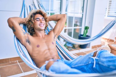 Genç İspanyol adam rahatlamış gülümsüyor mutlu bir şekilde terasta yatıyordu..