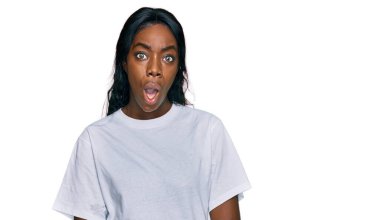 Genç Afro-Amerikalı kadın, günlük beyaz tişört giyiyor. Şaşırtıcı bir ifade, korku ve heyecan dolu bir yüz ifadesi var.. 