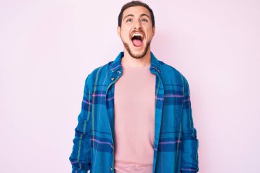 Genç, yakışıklı, rahat kıyafetler giyen sinirli ve kızgın bağıran sinirli sinirli ve öfkeliydi. Öfkeyle bağırıyordu. öfke ve agresif konsept. 