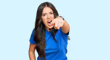 Güzel, esmer, gündelik giysiler giymiş genç bir kadın kameraya kızgın ve sinirli bir şekilde seni işaret ediyor. 