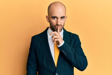 Genç İspanyol takım elbiseli ve kravatlı adam parmakları dudaklarında sessiz olmak istiyor. sessizlik ve gizli konsept. 
