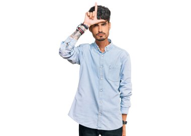 Latin asıllı genç adam sıradan kıyafetler giyiyor. Alnında parmakları olan insanlarla dalga geçiyor. Ezik hareketler yapıyor, alay ediyor, hakaret ediyor.. 