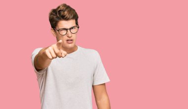 Sıradan kıyafetler ve gözlük takan yakışıklı beyaz adam kameraya kızgın ve sinirli olduğunu gösteriyor. 