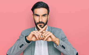 İş kıyafetleri giyen İspanyol genç adam reddedilme ifadesini olumsuz işaret yaparak şans diliyor. 