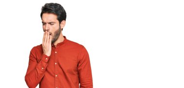 Gündelik kıyafetler giyen genç İspanyol adam ağzıyla ağzını kapatmaktan sıkılmış. Huzursuz ve uykulu.. 