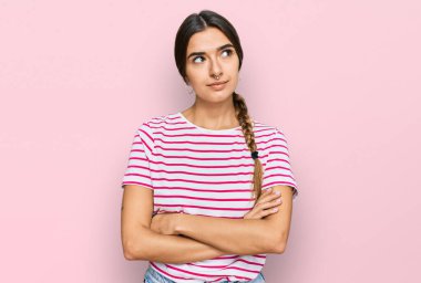 Gündelik kıyafetler giyen genç İspanyol kadın gülümseyip yan tarafa bakıyor ve düşünüyor.. 