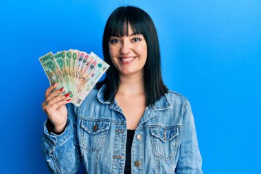 Birleşik Arap Emirlikleri 'ni elinde tutan genç İspanyol kadın gülümseyen bir gülümsemeyle pozitif ve mutlu görünüyor. 