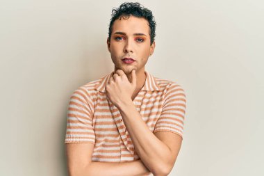 Makyaj yapan yakışıklı, rahat gömlekli, aklı başında, aklı başında, kendine güvenen bir adam. 