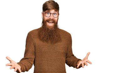 Young irish redhead man wearing casual clothes and glasses smiling cheerful with open arms as friendly welcome, positive and confident greetings 