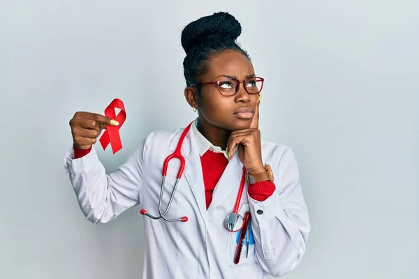 Joven Mujer Afroamericana Vistiendo Uniforme Médico Sosteniendo Apoyo Cinta Roja —  Fotos de Stock