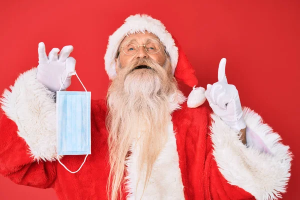 Velho Homem Sênior Vestindo Traje Papai Noel Segurando Máscara Segurança — Fotografia de Stock