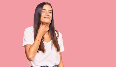 Young hispanic woman wearing casual white tshirt touching painful neck, sore throat for flu, clod and infection 