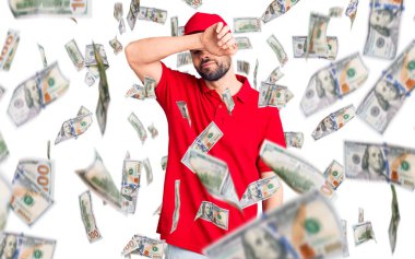 Sakallı genç yakışıklı adam teslimat üniforması giyiyor gözleri kollarıyla kapatıyor, ciddi ve üzgün görünüyor. Görme, saklama ve reddetme konsepti