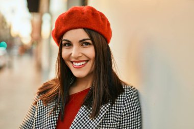 Genç İspanyol kadın gülümseyerek şehirde mutlu mesut dikiliyor..